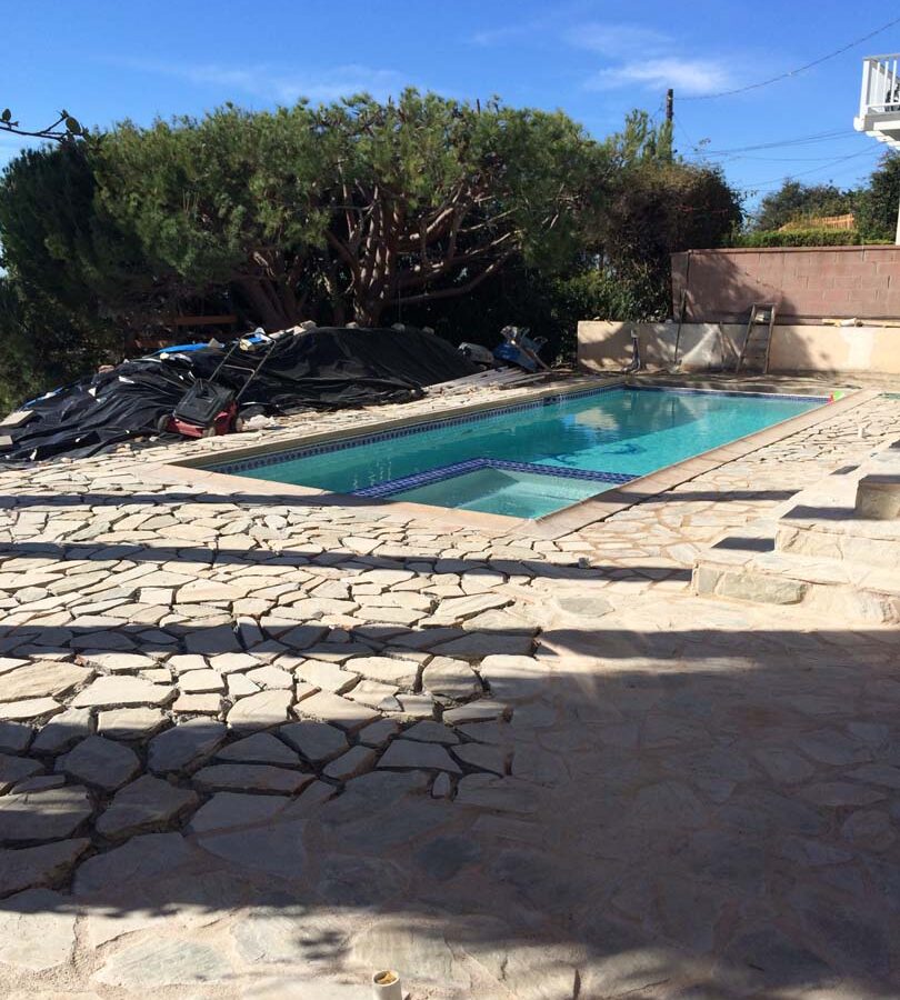 Old flagstone pool deck yet the existing flagstone still under construction. Pacificland Constructors