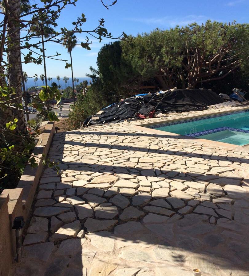 Old flagstone pool deck yet the existing flagstone still under construction. Pacificland Constructors