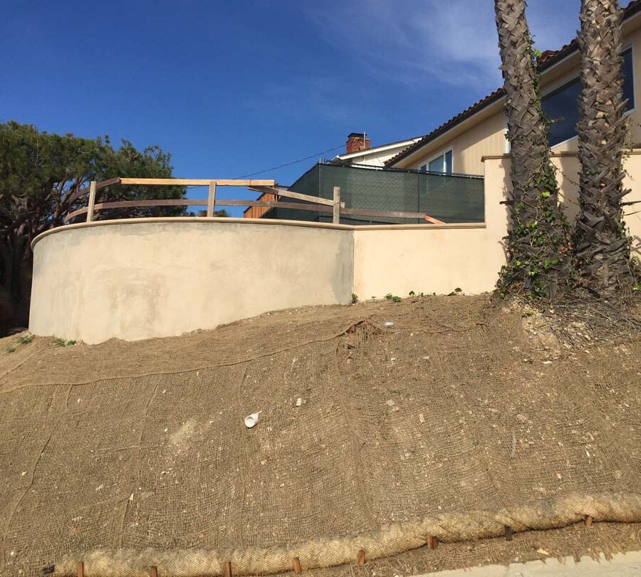 Construction of a new retaining wall with a colored concrete precast. Pacificland Constructors