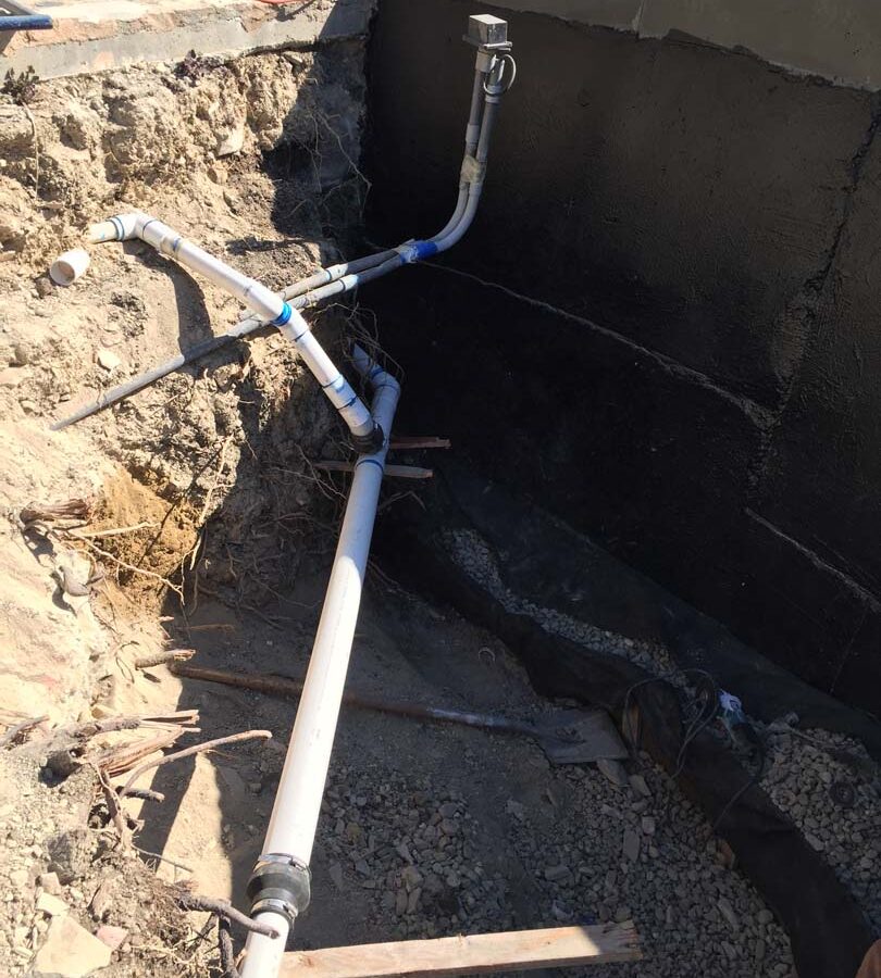 Waterproofing and pipe drainage that is buried is being compacted in place. New electrical pipe connections shown will also be buried out of sight. Pacificland Constructors