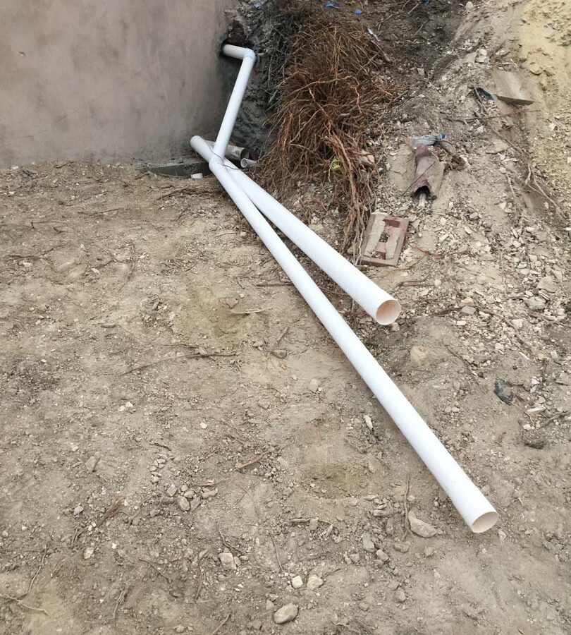 Waterproofing and pipe drainage that is buried is being compacted in place and extracted through a core hole in the retaining wall. Pacificland Constructors