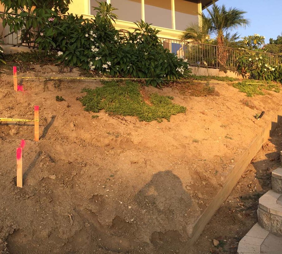 Construction of a new retaining wall long the slope of the hill. Pacificland Constructors