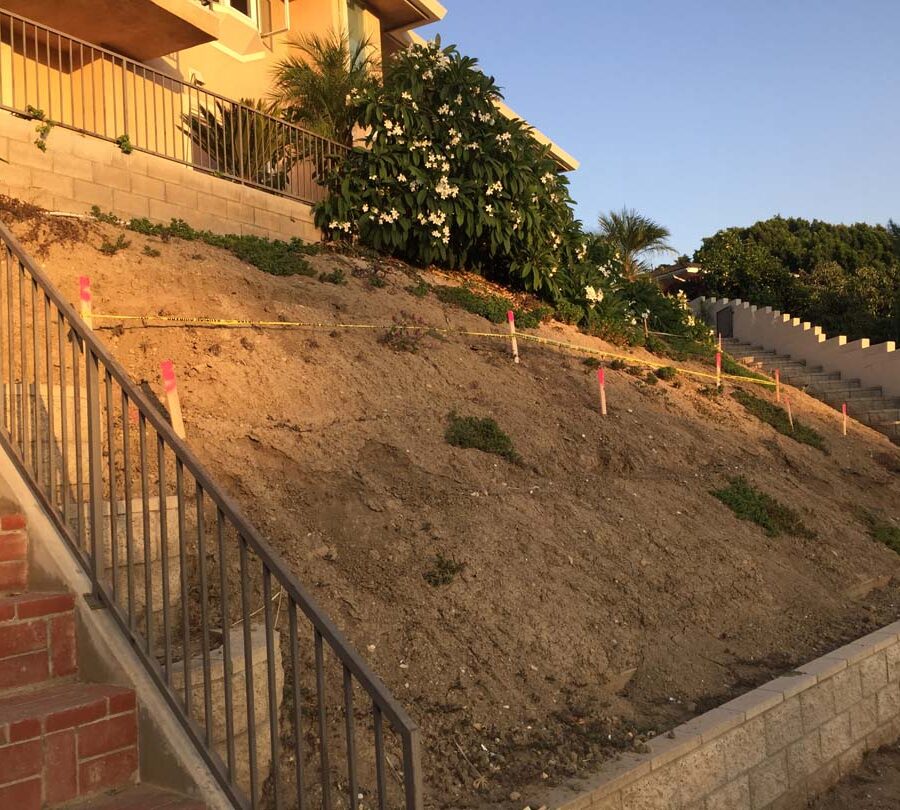 Construction of a new retaining wall long the slope of the hill. Pacificland Constructors