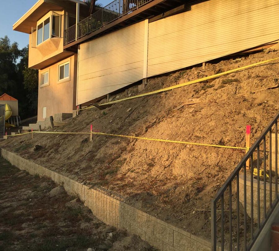 Construction of a new retaining wall long the slope of the hill. Pacificland Constructors