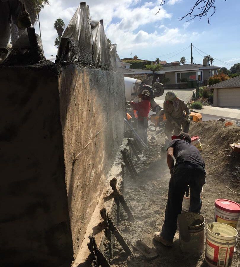 Construction of a new retaining wall shotcrete shooting, leveling, and color staining. Pacificland Constructors