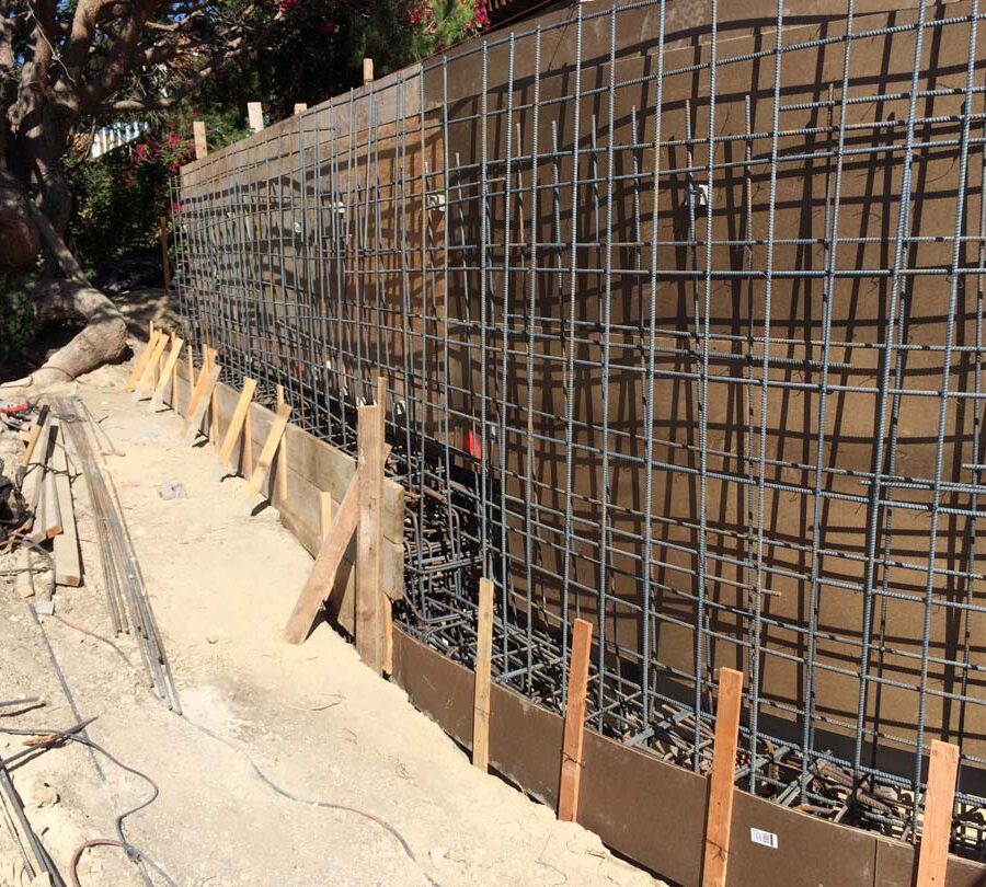 Construction of a new retaining wall steel rebar reinforcement. Pacificland Constructors