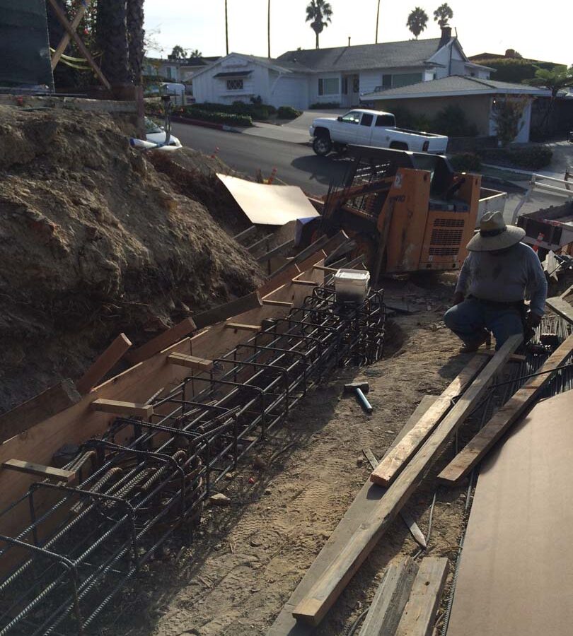 Construction of a new retaining wall steel rebar reinforcement for grade beam and formwork for the retaining wall. Pacificland Constructors