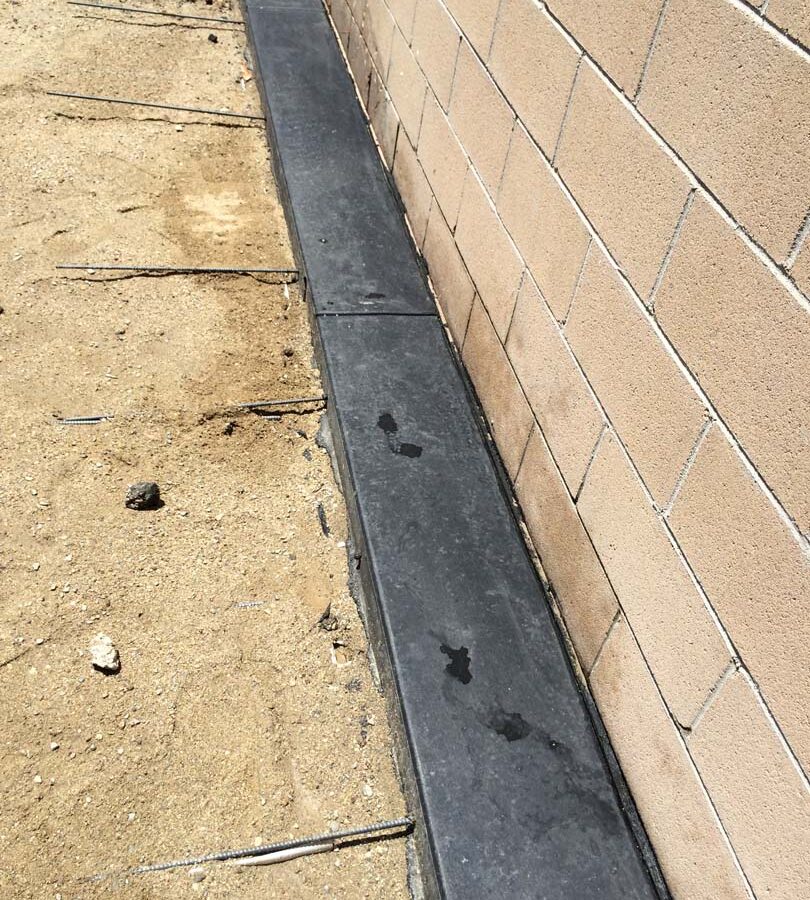 New dark concrete ribbon connected to a concrete patio. Pacificland Constructors