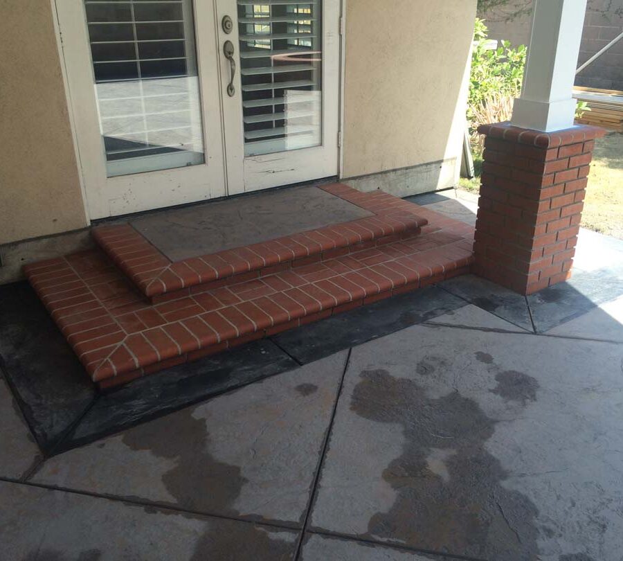 New bull-nosed brick steps with a colored backyard patio. Pacificland Constructors