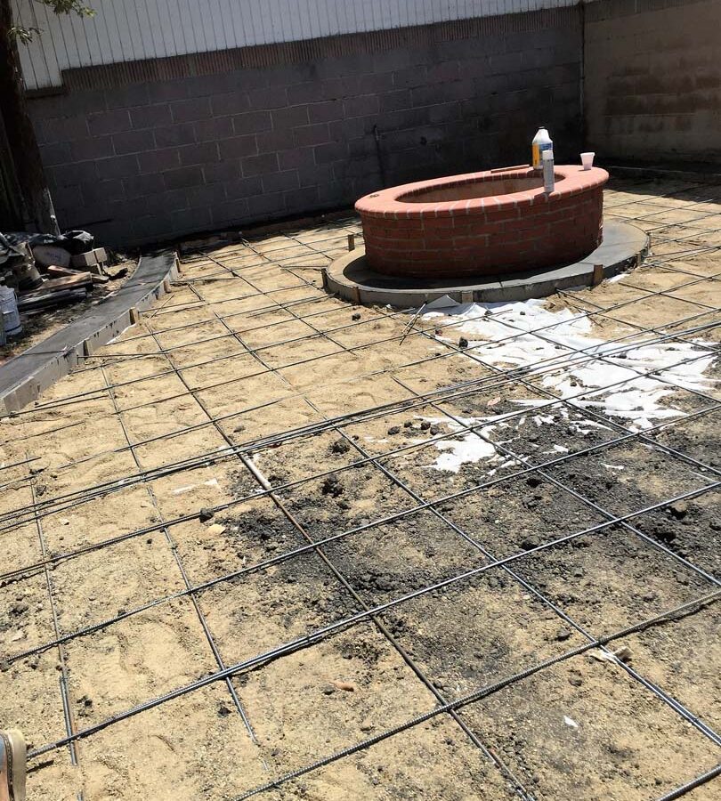 New dark concrete ribbon connected to a concrete patio. Pacificland Constructors