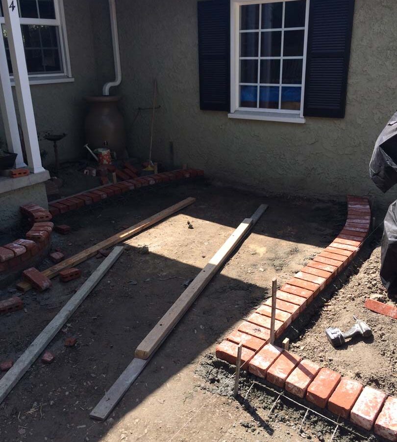 Construction of new front patio with brick ribbons that are manufactured white stains that will create a vintage look. Pacificland Constructors