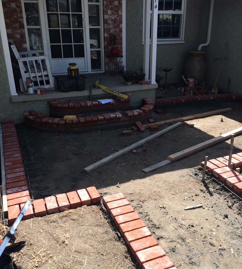 Construction of new front patio with brick ribbons that are manufactured white stains that will create a vintage look. Pacificland Constructors