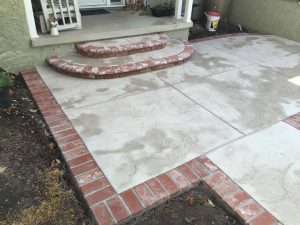 Stamped concrete flatwork with brick ribbon and steps.