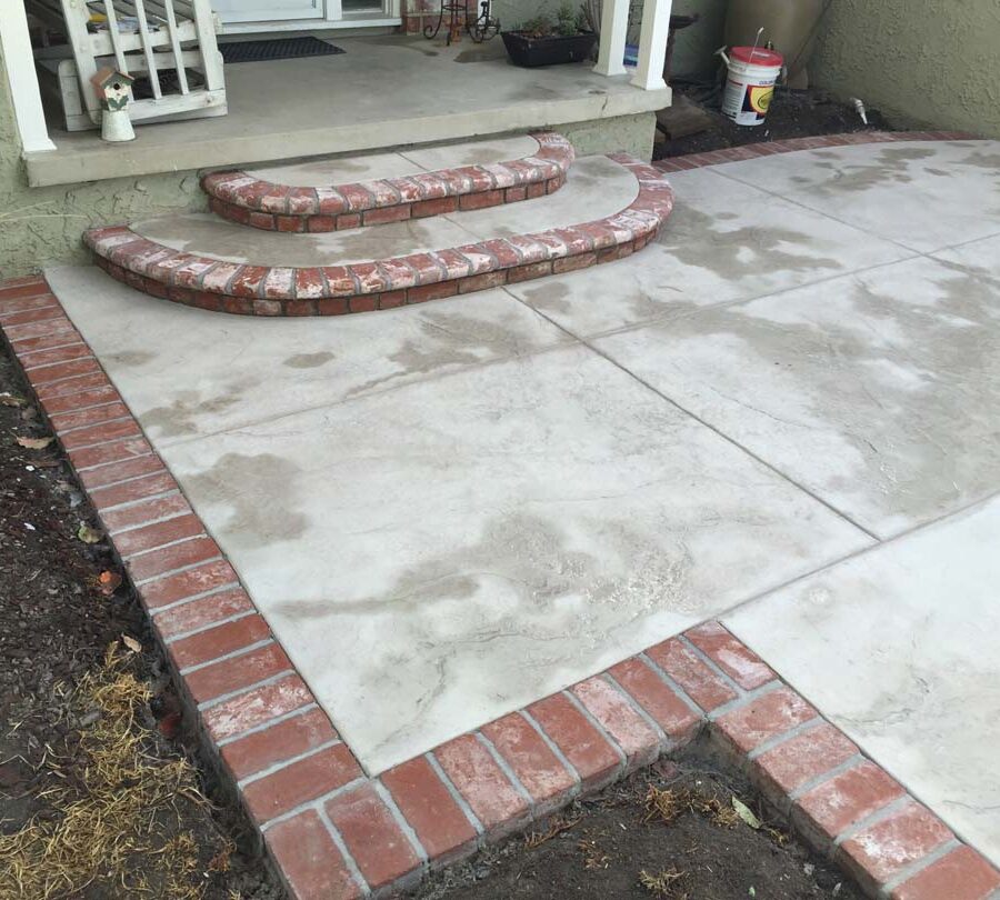 Stamped concrete flatwork with brick ribbon and steps.