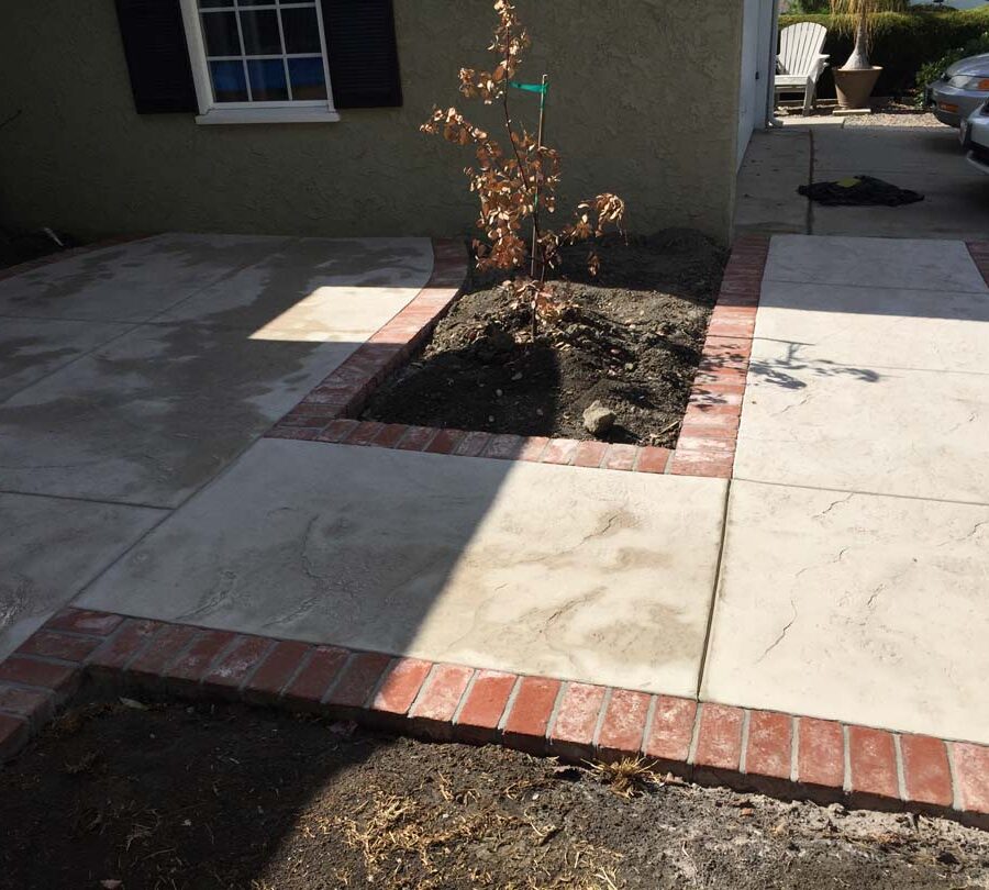 New stamped concrete flatwork with brick ribbon and steps.