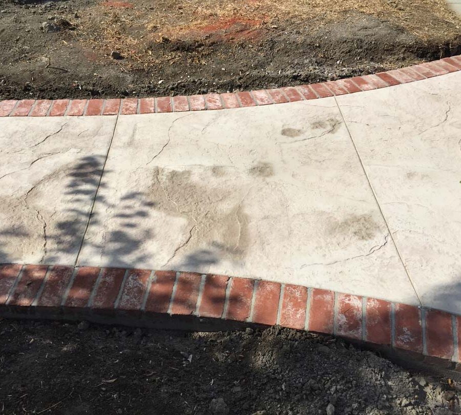 Stamped concrete with brick ribbons and handmade joints.