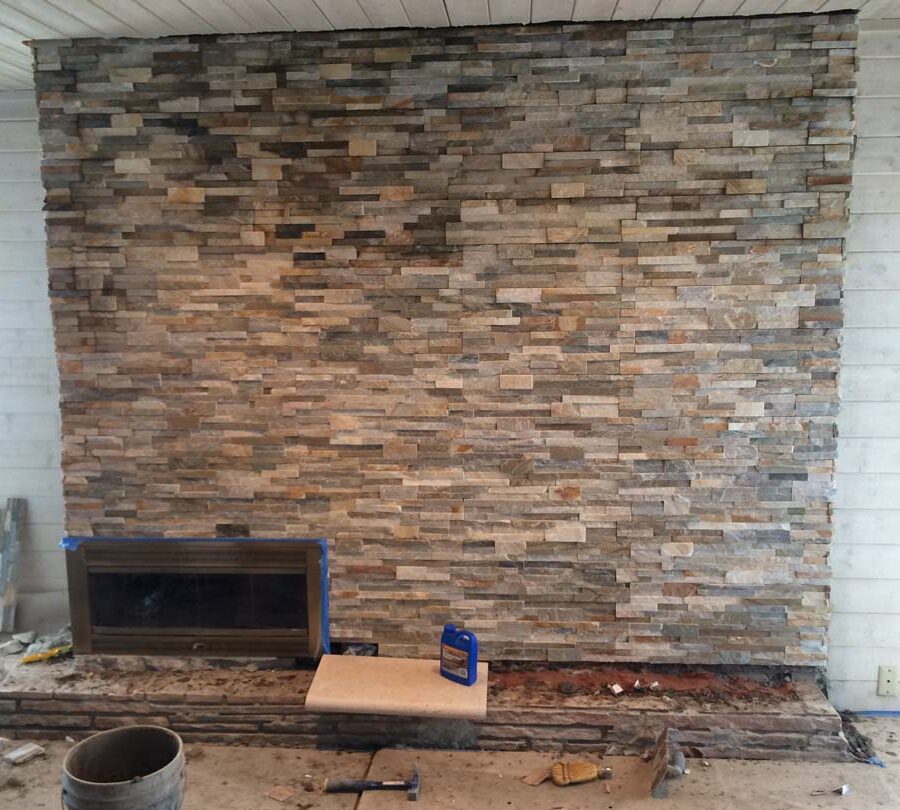 Construction of stone veneer for a chimney. This creates a great natural and relaxing theme for this home’s living room.