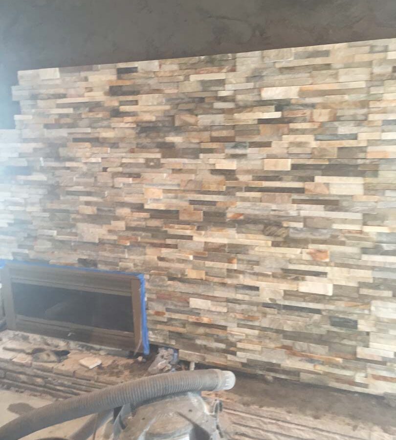 Construction of stone veneer for a chimney. This creates a great natural and relaxing theme for this home’s living room.