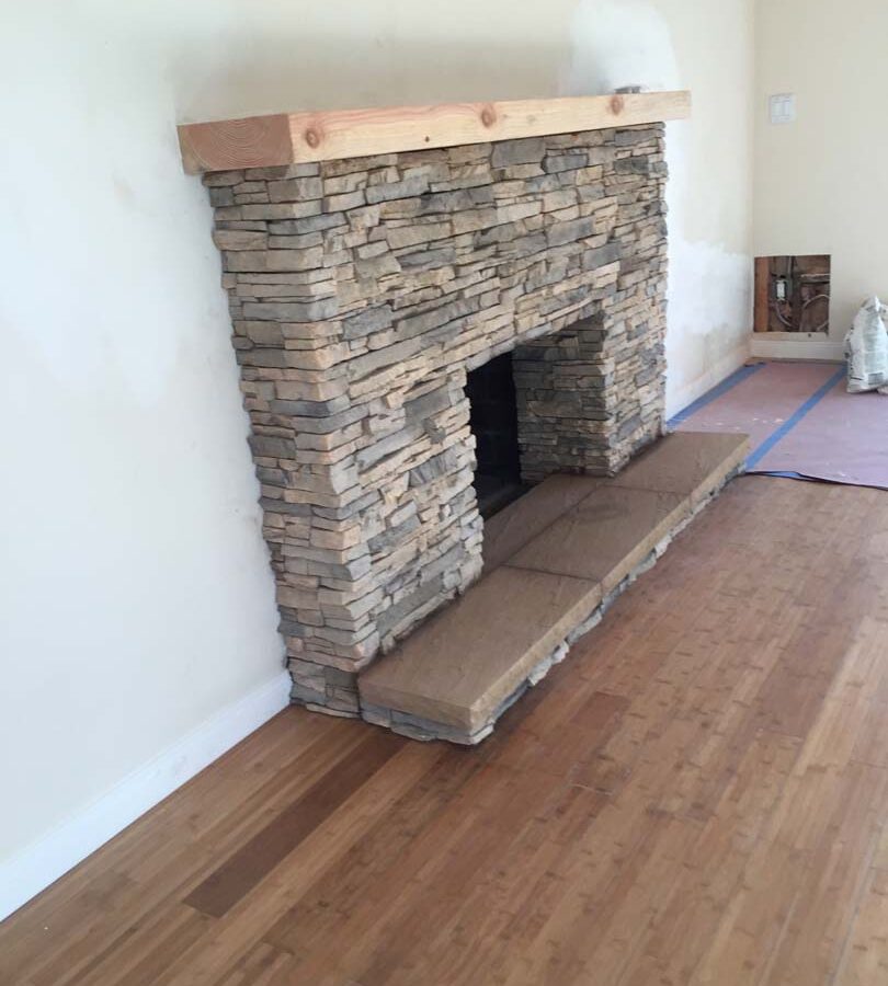 New stone veneer over the existing fireplace to create a vintage theme for the home. Pacificland Constructors