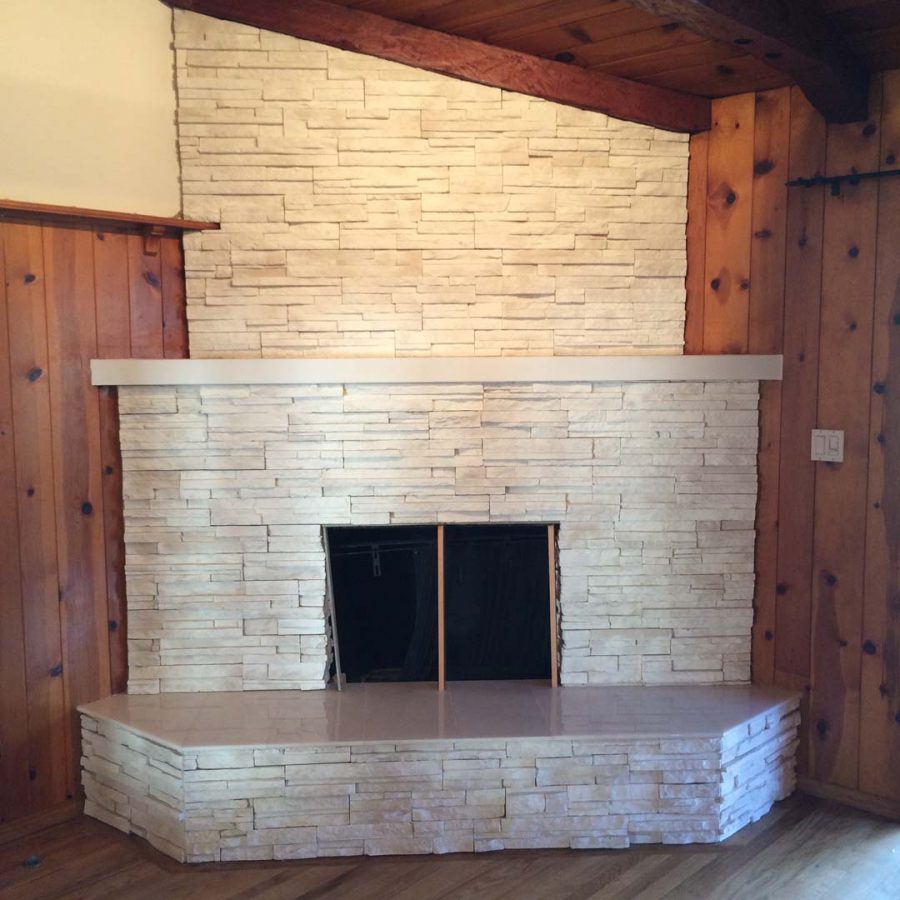 This white stone veneer fireplace with a marble/granite outer hearth will warm up the home during the winter holidays. Pacificland Constructors