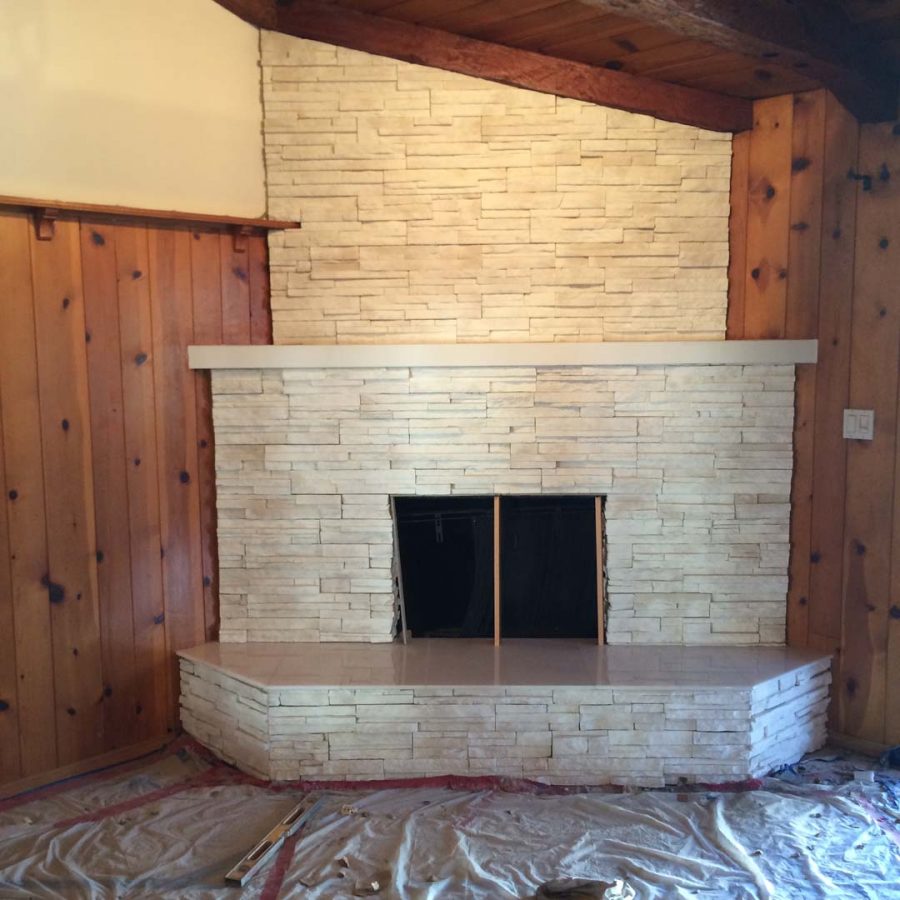 This white stone veneer fireplace with a marble/granite outer hearth will warm up the home during the winter holidays. Pacificland Constructors