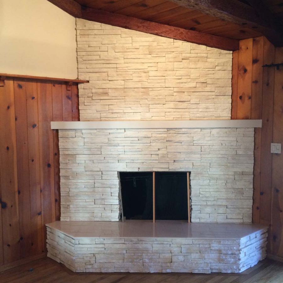 This white stone veneer fireplace with a marble/granite outer hearth will warm up the home during the winter holidays. Pacificland Constructors