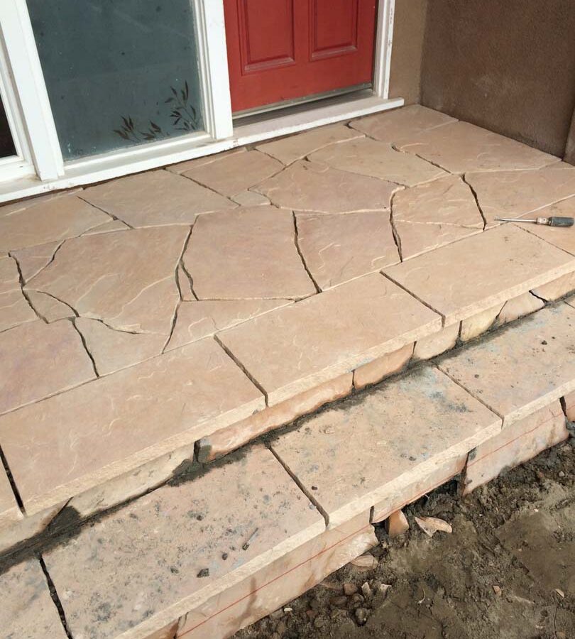 Custom stone cut slabs used as a walkway for a home’s entrance. Pacificland Constructors