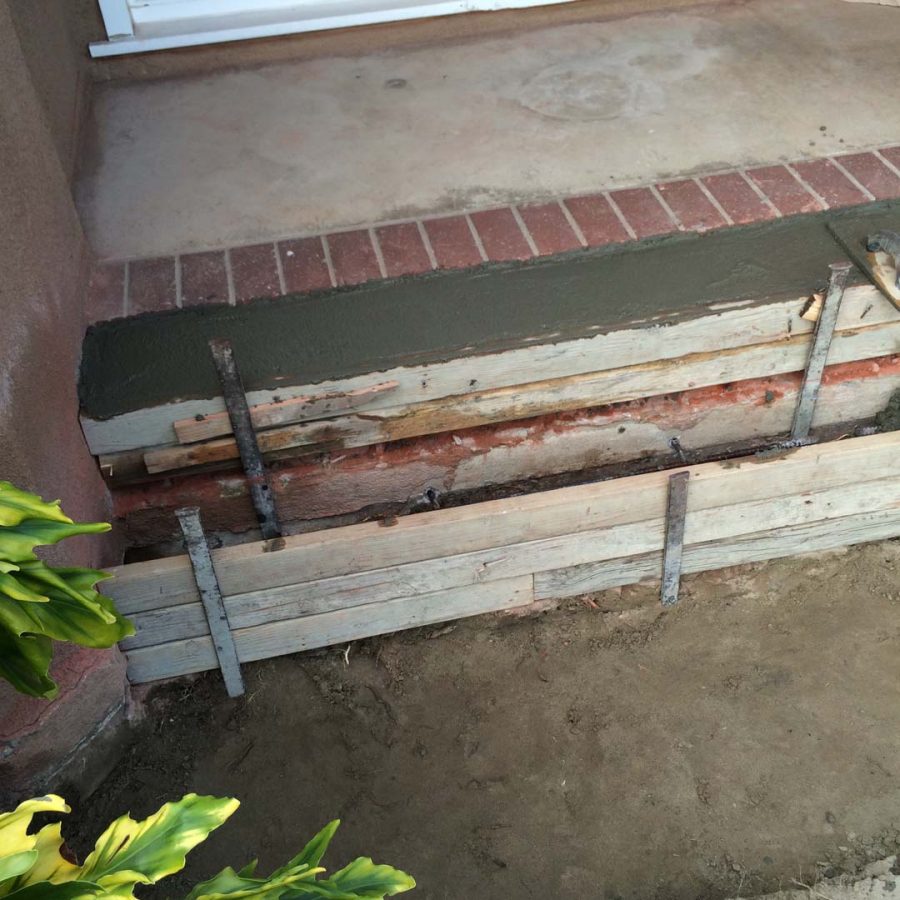 Construction of custom stone cut slabs used as a walkway for a home’s entrance. Pacificland Constructors