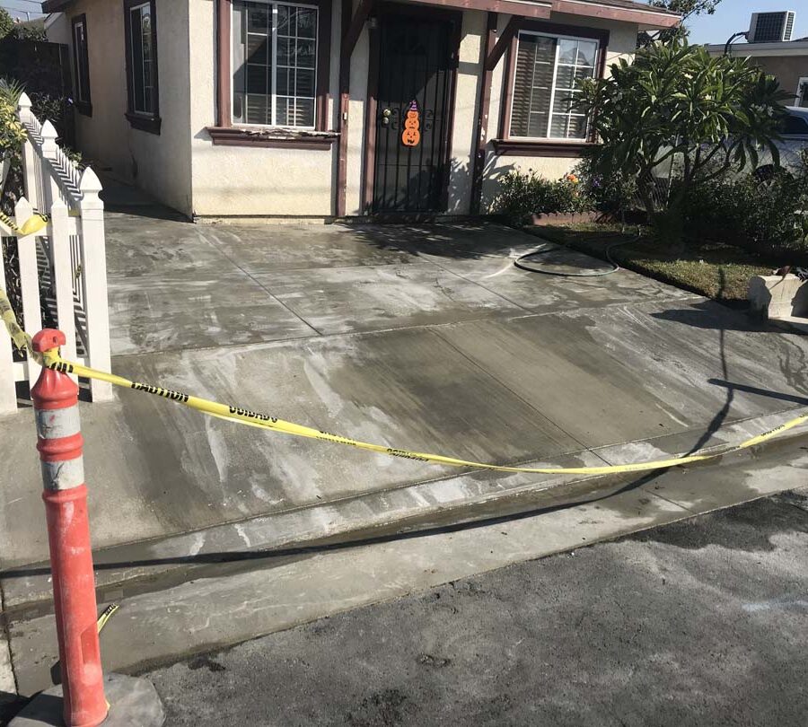 Finished concrete driveway with broomswept finish and hand scorched joints. Pacificland Constructors