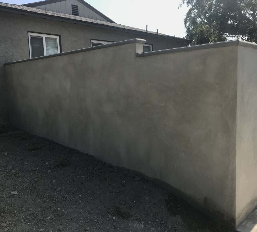 CMU block wall with a smooth stucco finish topped off with stepstone caps. Pacificland Constructors