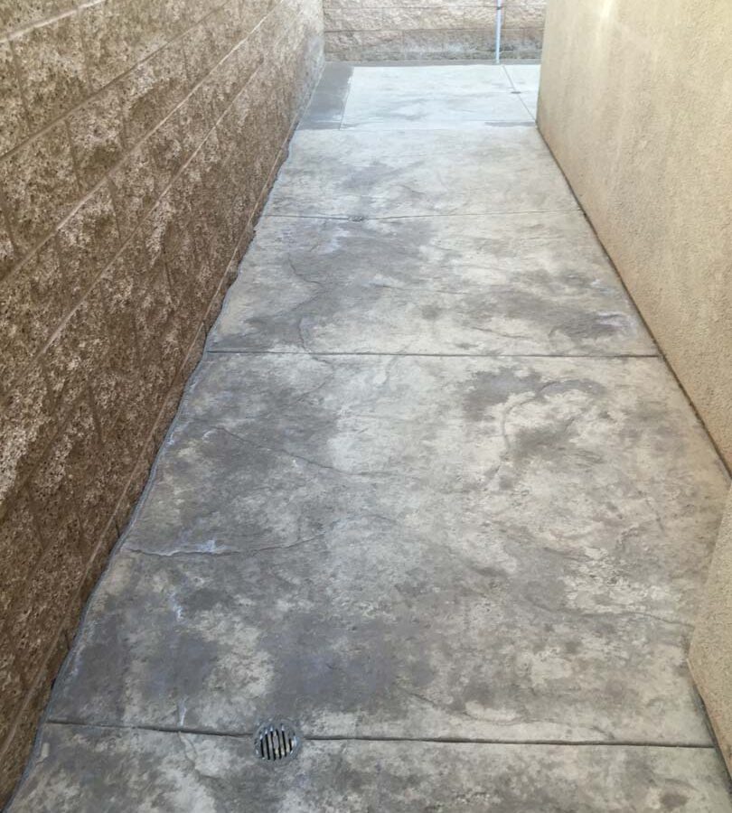 Gray stamped concrete and new CMU tan split face block wall. Pacificland Constructors