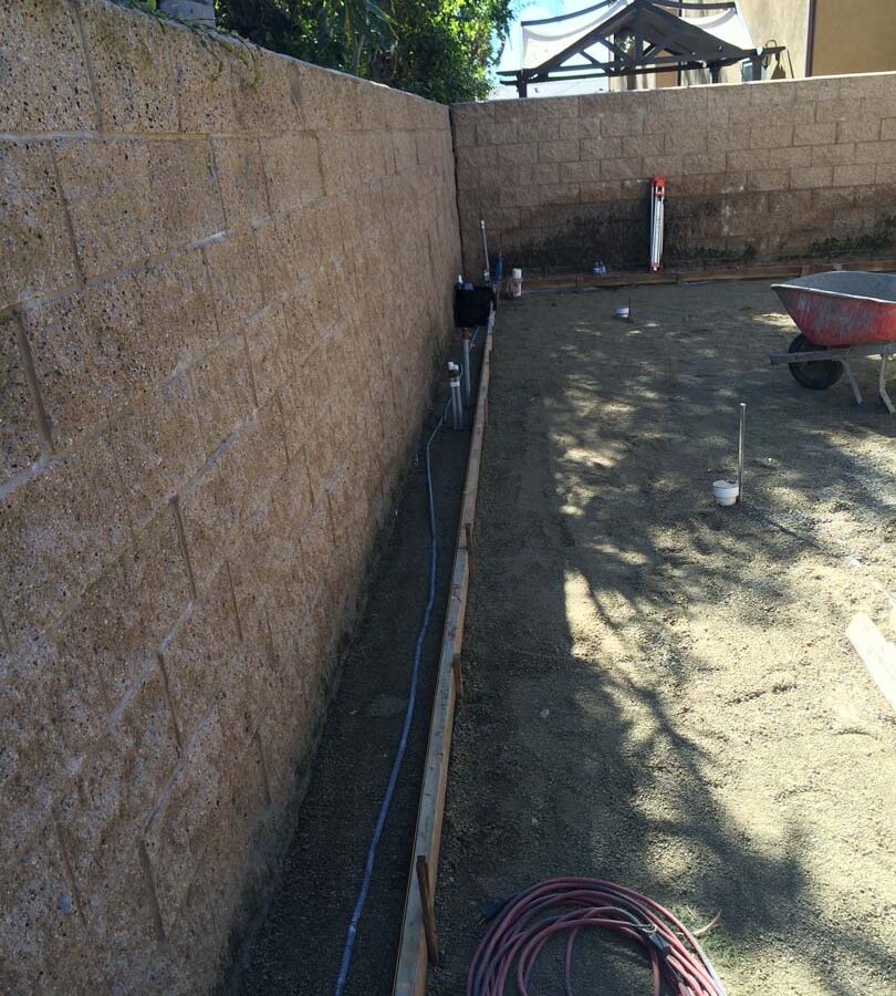 Grading and formwork construction for a new colored stamped concrete backyard in Bellflower, CA. We installed a drainage system throughout the backyard for optimal draining. Pacificland Constructors