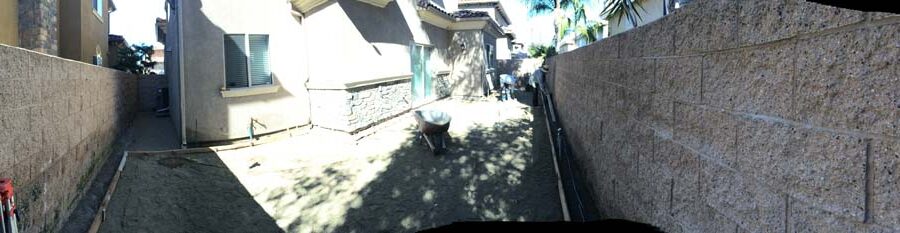 Panoramic view of the construction for a new colored stamped concrete backyard in Bellflower, CA. Pacificland Constructors