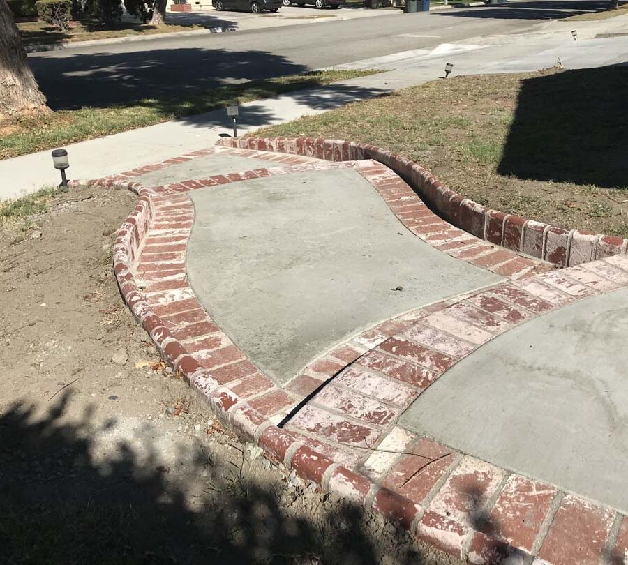 New beautiful curved front yard concrete walkway and steps with brick ribbon and bull-nosed steps. Pacificland Constructors