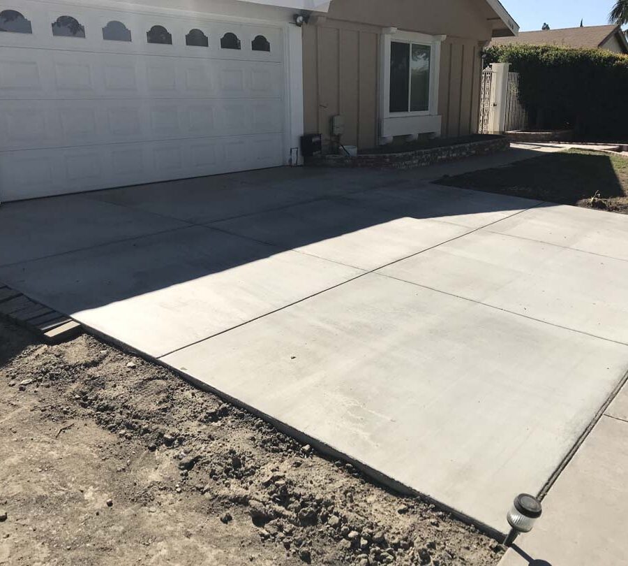 New broom swept concrete driveway with hand scorched joints. Concrete will always crack. These hand scorched joints are intended to control these cracks in a manner that the slab still keeps its cosmetic and structural integrity. Pacificland Constructors