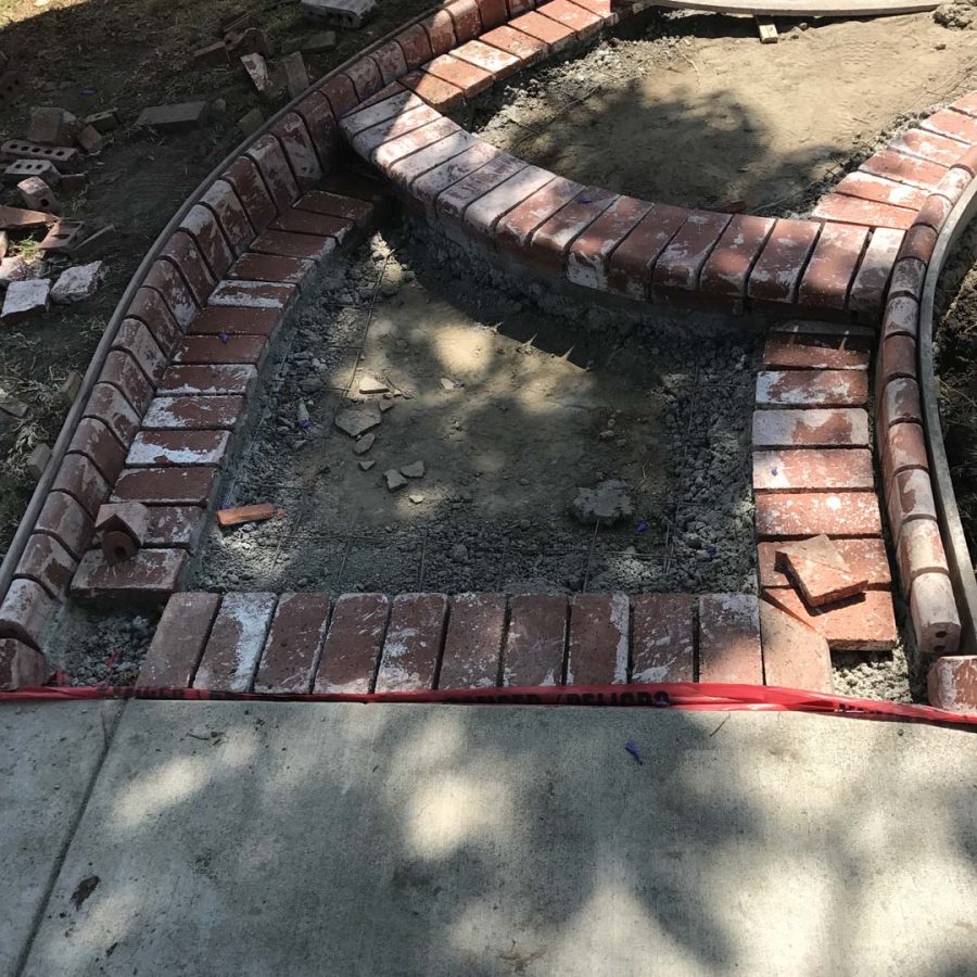 Construction of a new beautiful curved front yard concrete walkway with brick ribbon bull-nosed steps. Pacificland Constructors