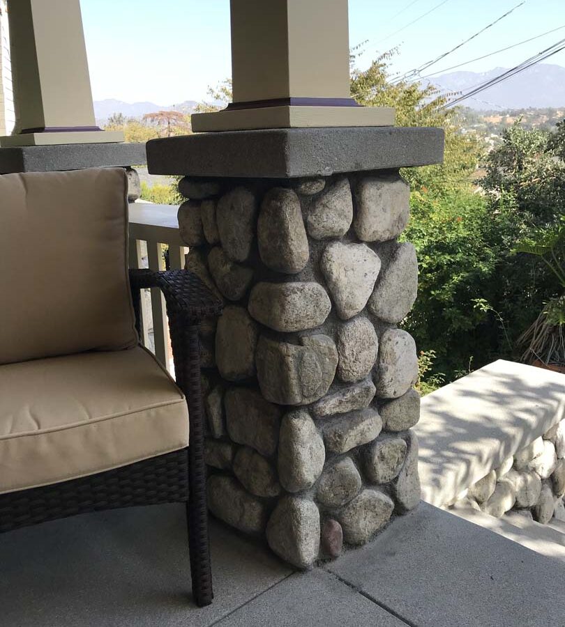 Cobble stone covered short wall topped off with a concrete poured wall cap. Pacificland Constructors