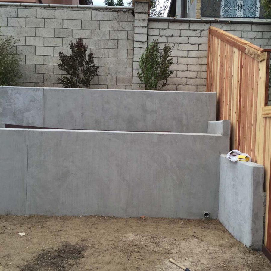 New pour in place concrete retaining wall for a backyard in Huntington Beach, CA. This retaining wall creates more flat area for the home because it holds up the differential earth elevation from the neighbor’s home. It also creates a planter for vegetation. Pacificland Constructors