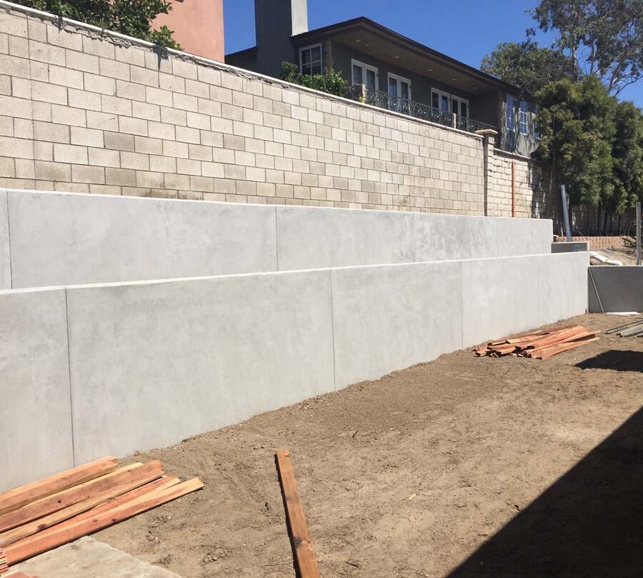 New pour in place concrete retaining wall for a backyard in Huntington Beach, CA. This retaining wall creates more flat area for the home because it holds up the differential earth elevation from the neighbor’s home. It also creates a planter for vegetation. Pacificland Constructors