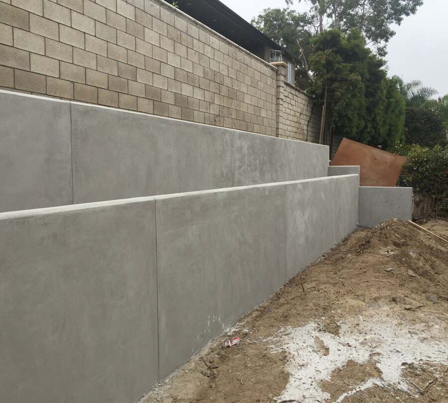 New pour in place concrete retaining wall for a backyard in Huntington Beach, CA. This retaining wall creates more flat area for the home because it holds up the differential earth elevation from the neighbor’s home. It also creates a planter for vegetation. Pacificland Constructors