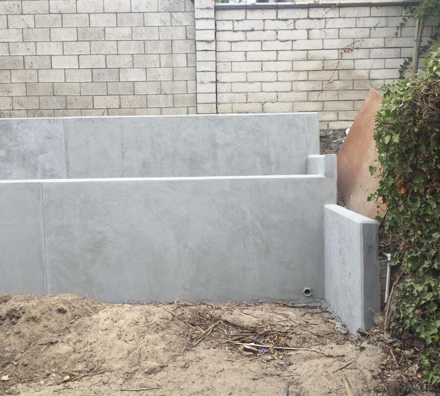 Construction of a new concrete retaining wall for a backyard in Huntington Beach, CA. This retaining wall creates more flat area for the home because it holds up the differential earth elevation from the neighbor’s home. It will also serve as a planter for vegetation. Pacificland Constructors