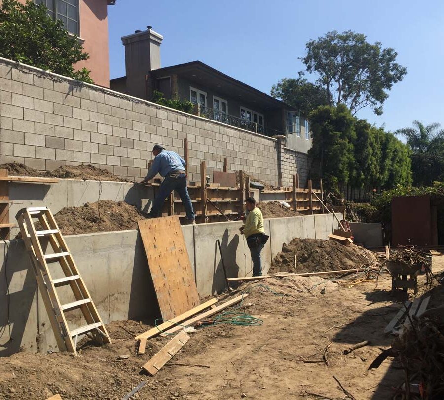 Construction of a new concrete retaining wall for a backyard in Huntington Beach, CA. Here Pacificland is stripping off the forms off the poured in place concrete retaining walls. Pacificland Constructors