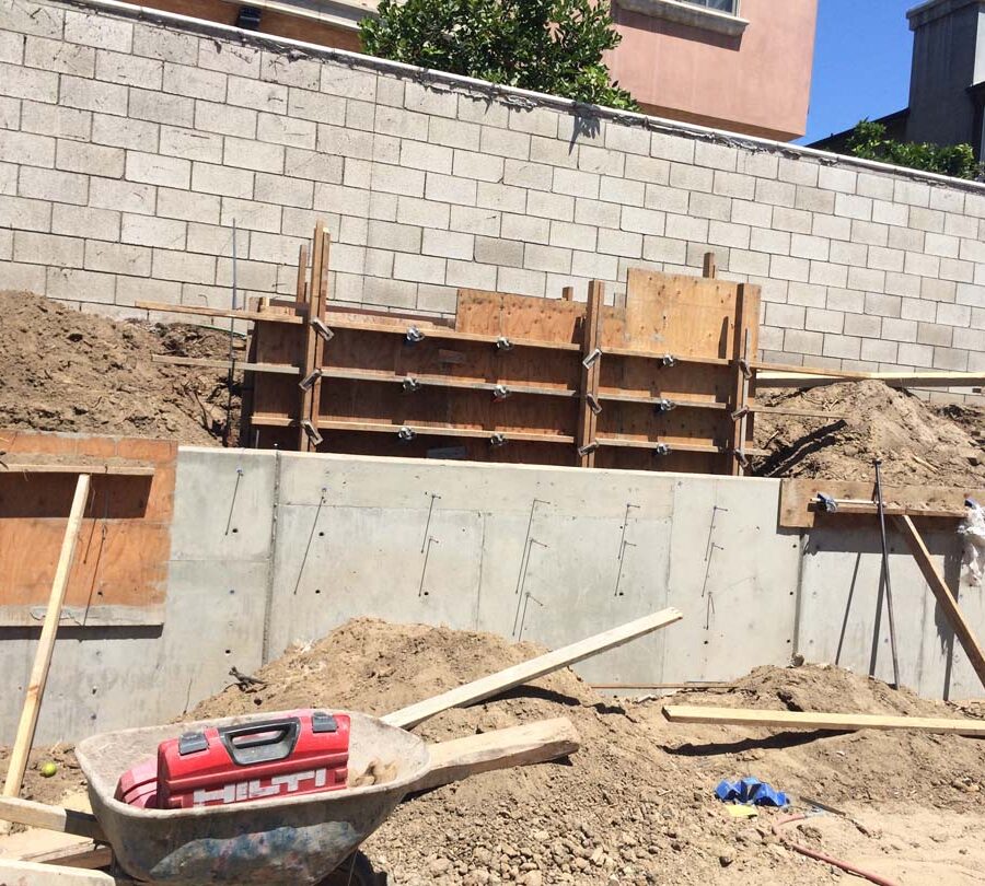 Formwork carpentry and reinforcement for a new concrete retaining wall for a backyard in Huntington Beach, CA. Pacificland Constructors