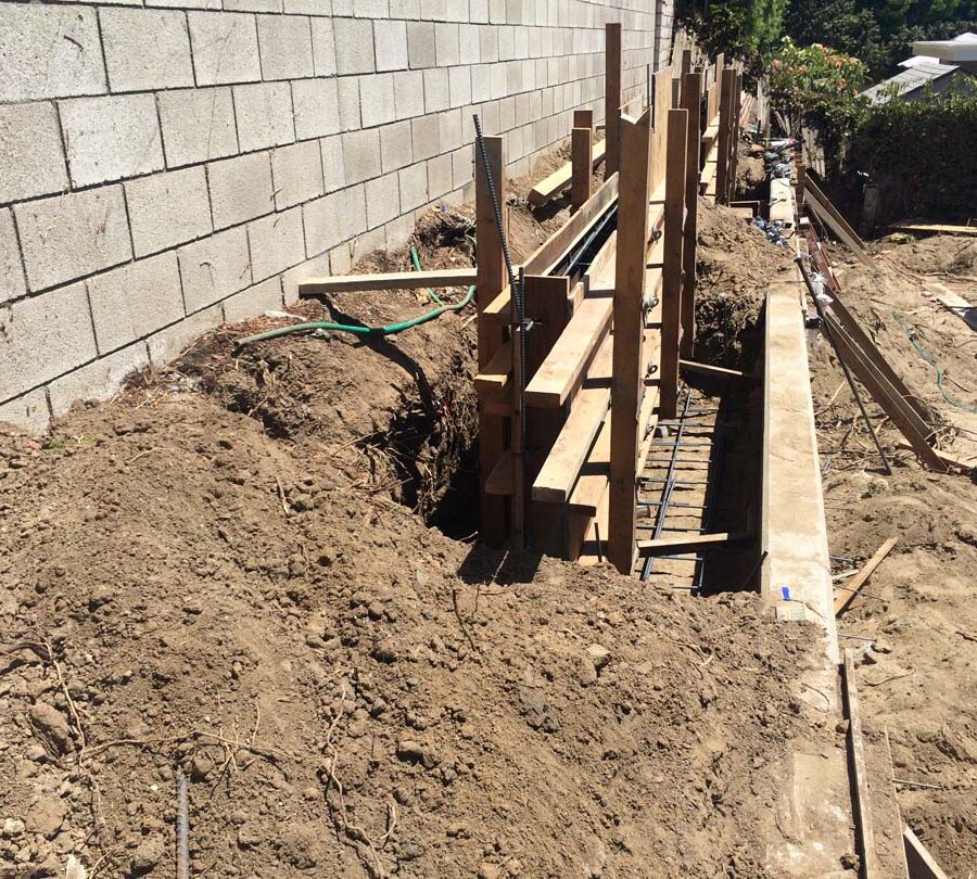 Formwork carpentry and reinforcement for a new concrete retaining wall for a backyard in Huntington Beach, CA. Pacificland Constructors