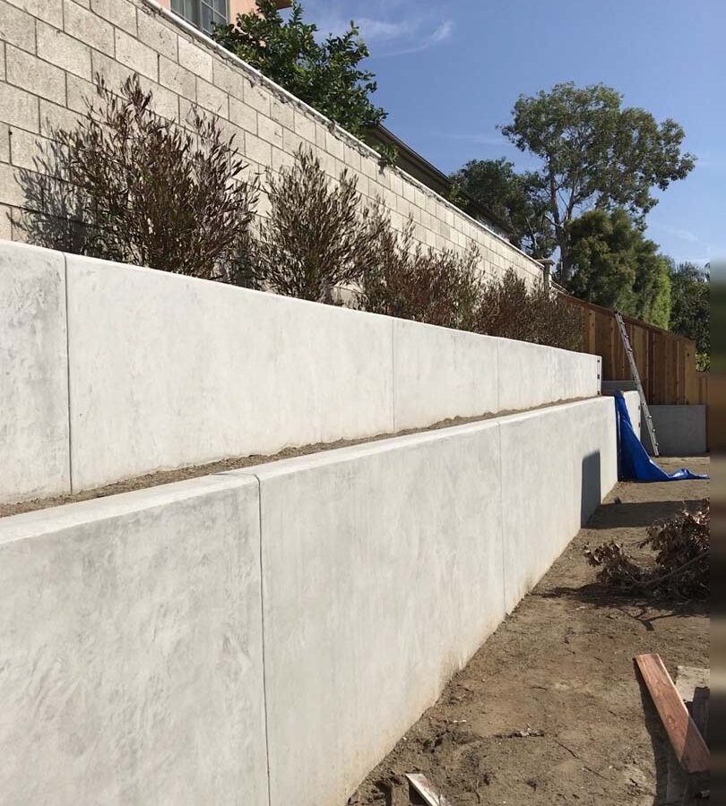 New pour in place concrete retaining wall for a backyard in Huntington Beach, CA. This retaining wall creates more flat area for the home because it holds up the differential earth elevation from the neighbor’s home. Pacificland Constructors