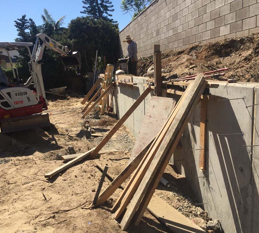 Stripping the formwork carpentry from this new concrete retaining wall for a backyard after pouring it. Pacificland Constructors