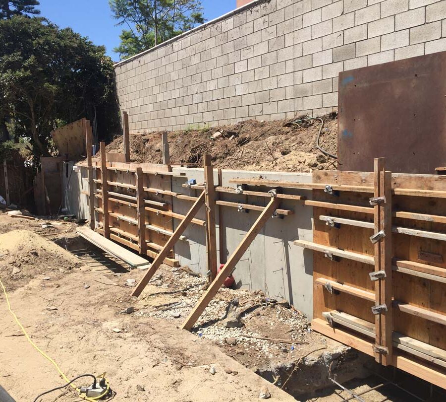 Formwork carpentry and reinforcement for a new concrete retaining wall for a backyard in Huntington Beach, CA. Pacificland Constructors