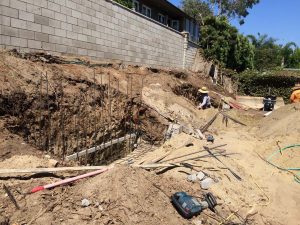 Reinforcement of strip footings with steel ironwork for a new section of concrete retaining wall. Pacificland Constructors