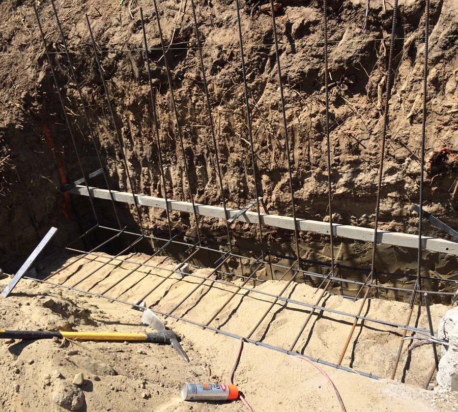 Reinforcement of strip footings with steel ironwork for a new section of concrete retaining wall. Pacificland Constructors