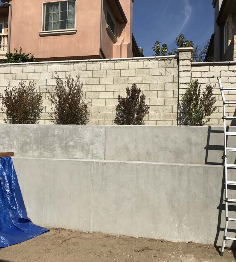 New pour in place concrete retaining wall for a backyard in Huntington Beach, CA. This retaining wall creates more flat area for the home because it holds up the differential earth elevation from the neighbor’s home. Pacificland Constructors